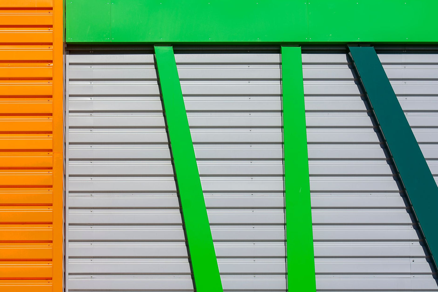 Close-up of colorful industrial facade with vibrant orange, green, and gray panels.