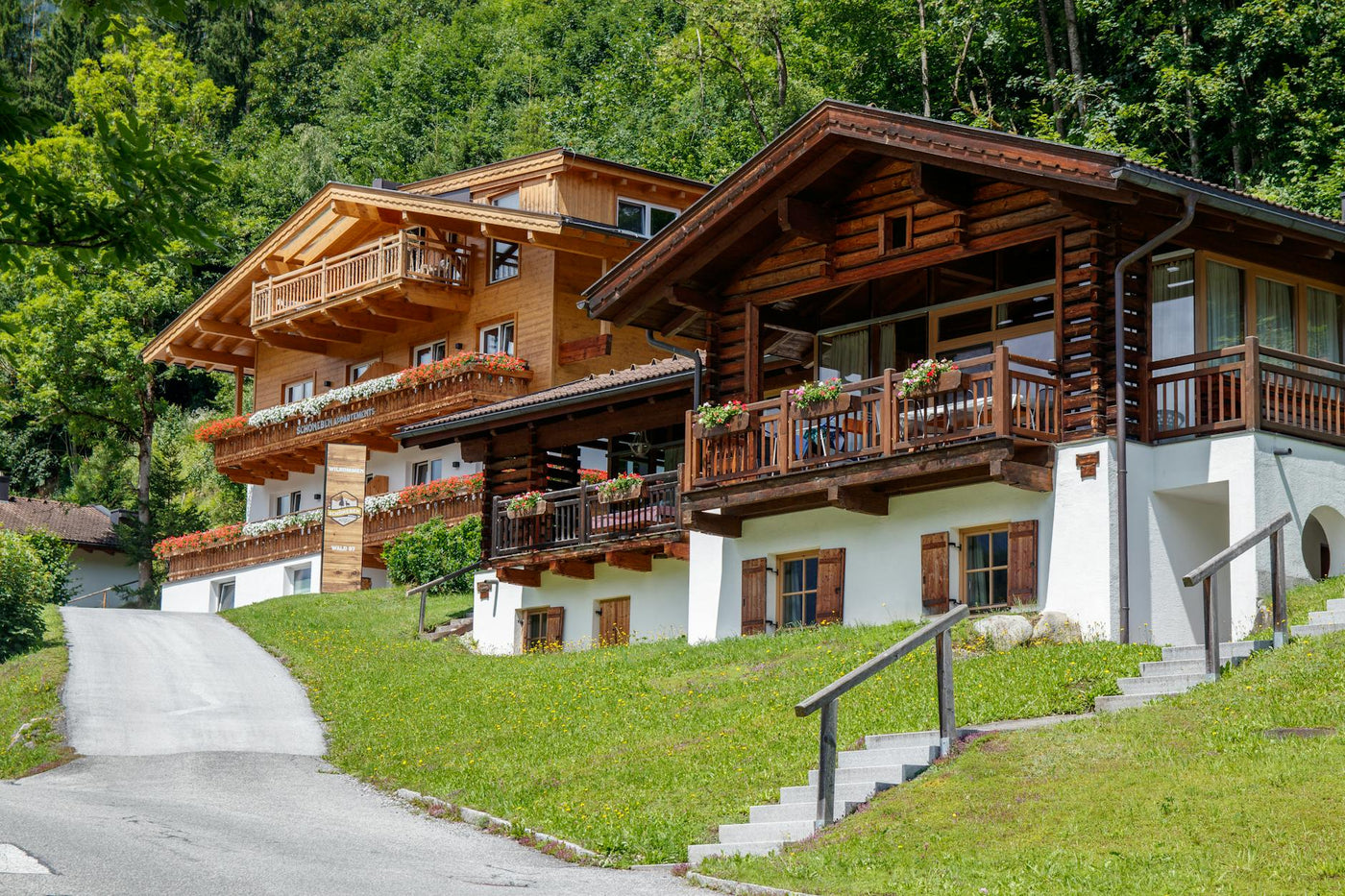 Cozy wooden chalets nestled in a picturesque mountain setting, surrounded by lush greenery.