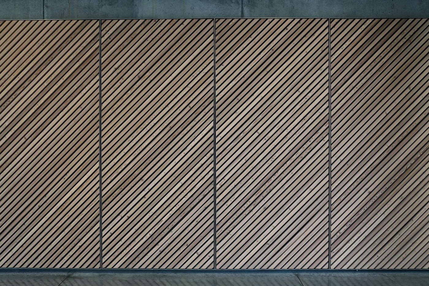 Abstract view of a diagonal wooden panel wall with a textured, patterned design.