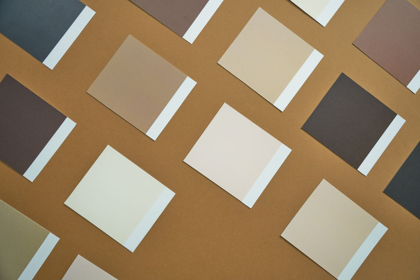 Flat lay of brown and beige paper swatches on a brown background, perfect for design inspiration.