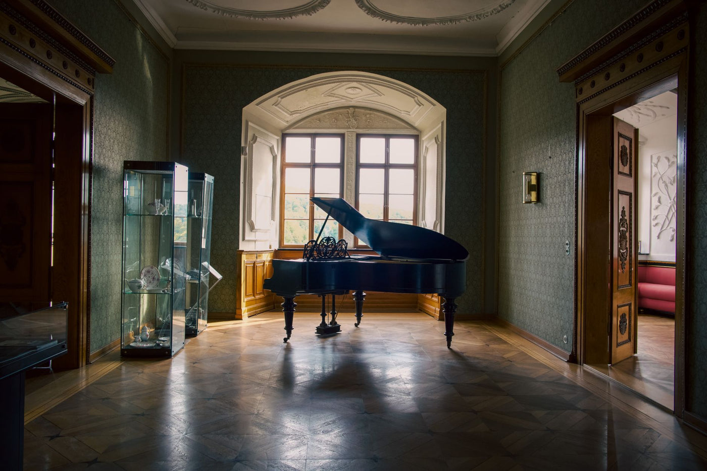 A grand piano illuminated by soft light in a luxurious room of Stolberg Castle, Germany.