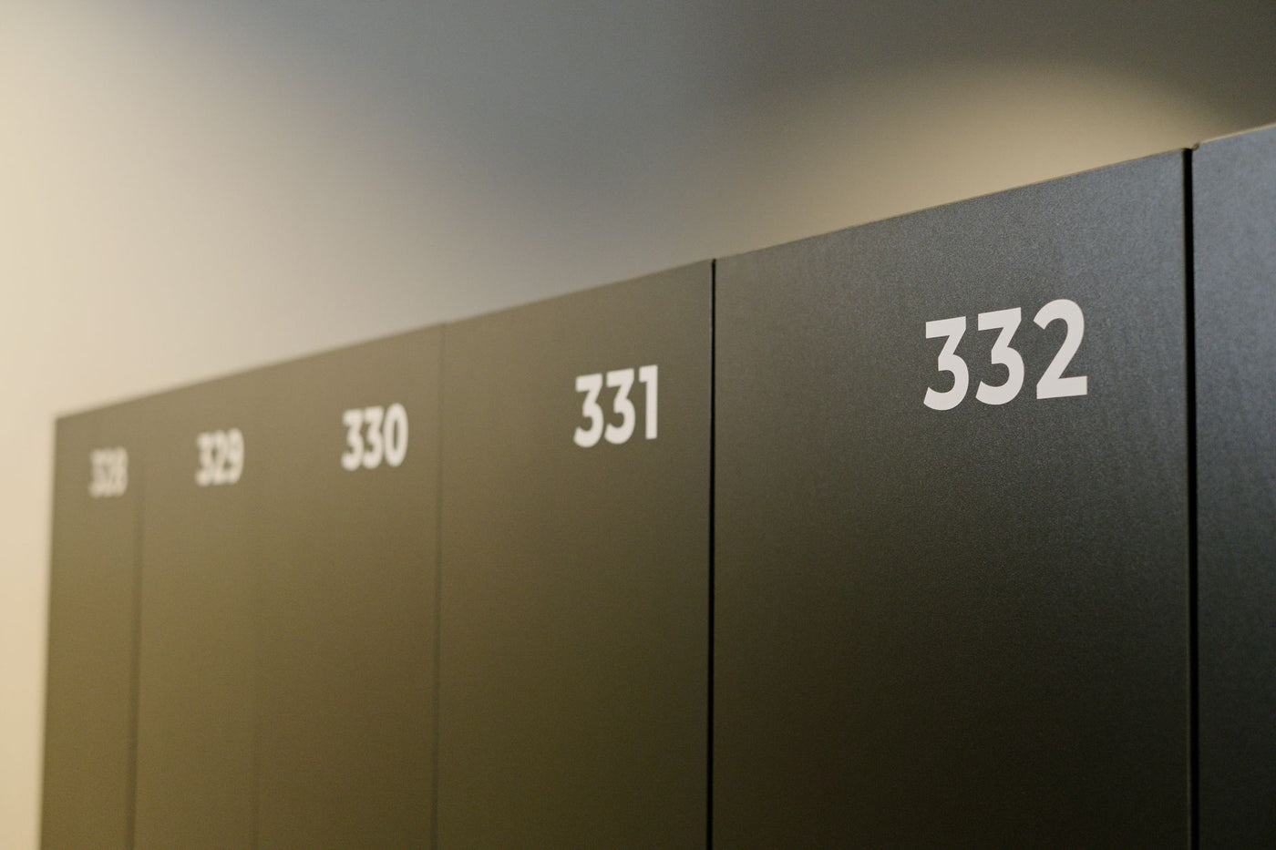Close-up of numbered lockers in a locker room, showcasing a minimalist design.